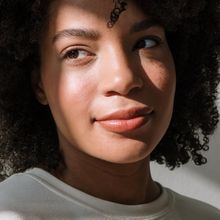 Portrait of a serene and dedicated yoga practitioner, a woman with a warm and gentle smile.
